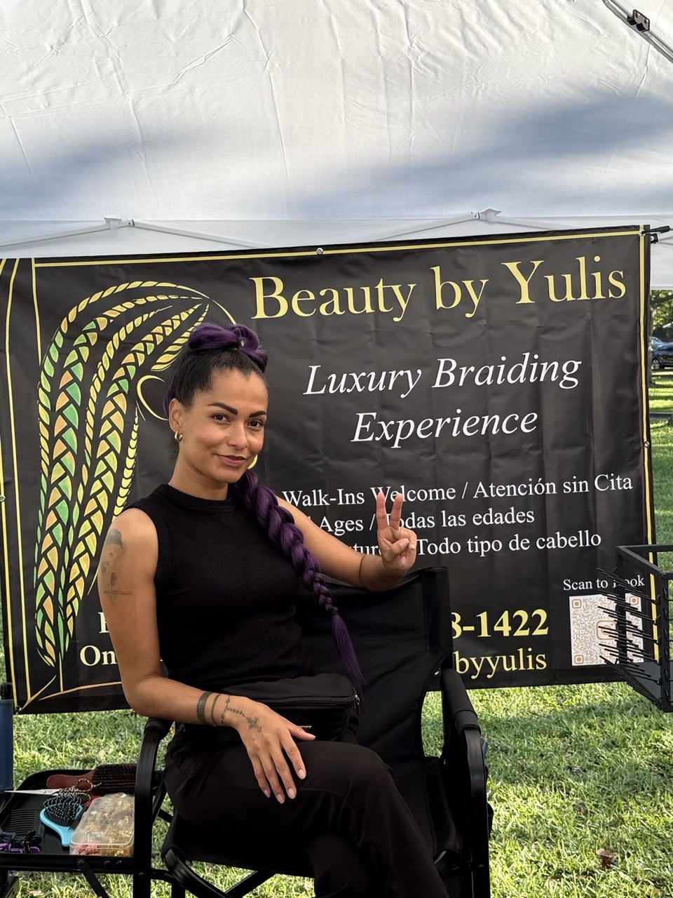 Yulis smiling in front of her business sign at BeautyByYulis